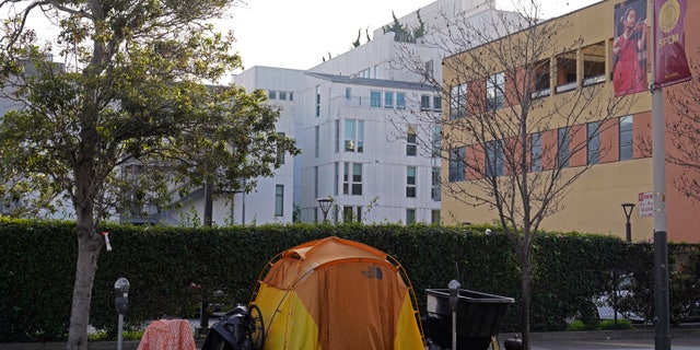 A tent is seen on a sidewalk just around the corner from the Opera House with a residential building in the background in San Francisco, Thursday, Dec. 2, 2021. (AP Photo/Eric Risberg)