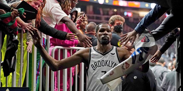 Brooklyn Nets forward Kevin Durant (7) makes his way past fans as he walks to the locker room after the Nets defeated the Atlanta Hawks in an NBA basketball game Friday, Dec. 10, 2021, in Atlanta.