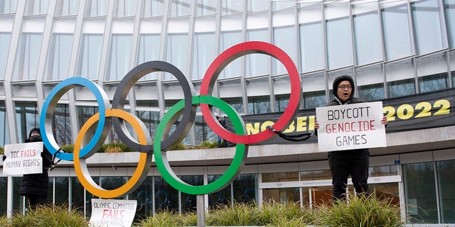 Protesters hold protest posters during a protest against Beijing 2022 Winter Olympics by activists of the Tibetan Youth Association in Europe front of the International Olympic Committee (IOC) headquarters in Lausanne, Switzerland, Saturday, Dec. 11, 2021.