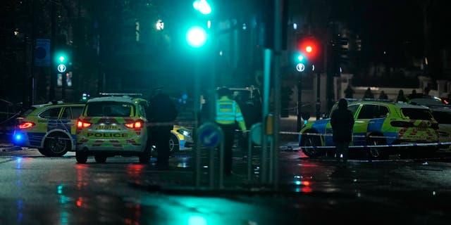 Police attend the scene near Kensington High Street in London, Saturday Dec. 11, 2021. (Aaron Chown/PA via AP)