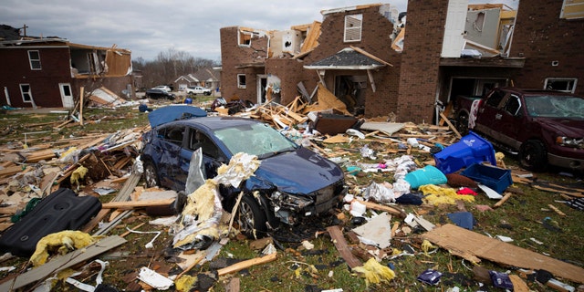 A car sits in the debris caused by a tornado in Bowling Green, Ky., Saturday, Dec. 11, 2021. A monstrous tornado killed dozens of people in Kentucky and the toll was climbing Saturday after severe weather ripped through at least five states, leaving widespread devastation. (AP Photo/Michael Clubb)