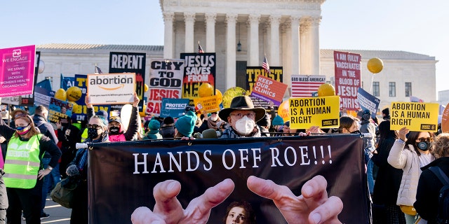 Stephen Parlato of Boulder, Colorado, holds a sign that reads "Hands Off Roe!!!" as abortion rights advocates and anti-abortion protesters demonstrate in front of the U.S. Supreme Court, Dec. 1, 2021, in Washington. 