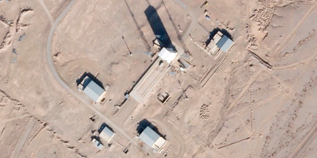 In this satellite photo by Planet Labs Inc., a support vehicle stands parked alongside a massive white gantry that typically houses a rocket on the launch pad as activity is seen at the Imam Khomeini Spaceport in Semnan province, 伊朗, 星期六, 十二月. 11, 2021. (Planet Labs Inc. via AP)