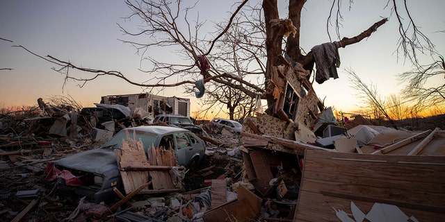 A car sits among the remains of a destroyed house after a tornado in Dawson Springs, Ky. (AP Photo/Michael Clubb)