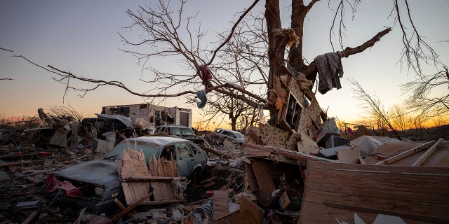 A car sits among the remains of a destroyed house after a tornado in Dawson Springs, Ky. (AP Photo/Michael Clubb)