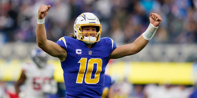 Los Angeles Chargers quarterback Justin Herbert celebrates after throwing a pass to wide receiver Jalen Guyton during the first half of an NFL game in Inglewood, California, on Dec. 12, 2021.