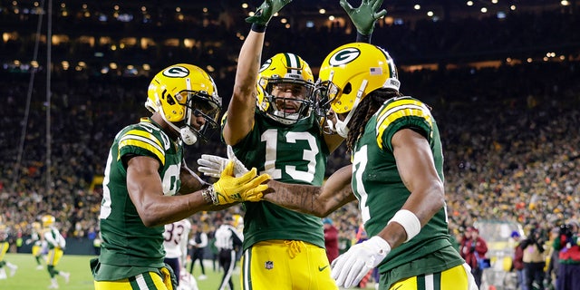 Green Bay Packers' Davante Adams celebrates his touchdown catch with Marquez Valdes-Scantling and Allen Lazard (13) during the first half of an NFL football game against the Chicago Bears Sunday, Dec. 12, 2021, in Green Bay, Wis. (AP Photo/Matt Ludtke)