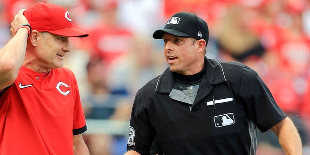 Cincinnati Reds manager David Bell, left, talks with umpire Tripp Gibson, right, between batters during the first inning of a baseball game against the San Diego Padres in Cincinnati, July 1, 2021. 