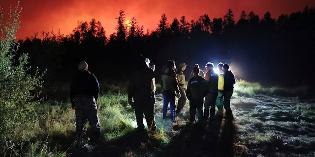 FILE - Firefighters and volunteers have a briefing as they work at the scene of forest fire at Gorny Ulus area west of Yakutsk, in Russia, Saturday, Aug. 7, 2021. (AP Photo/Ivan Nikiforov, File)