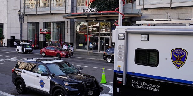 Police vehicles are stationed at Union Square following recent robberies in San Francisco.