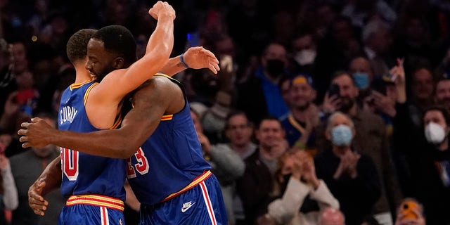 Golden State Warriors guard Stephen Curry (30) hugs forward Draymond Green (23) after scoring a 3-point basket during the first half of an NBA basketball game against the New York Knicks, Tuesday, Dec. 14, 2021, at Madison Square Garden in New York.