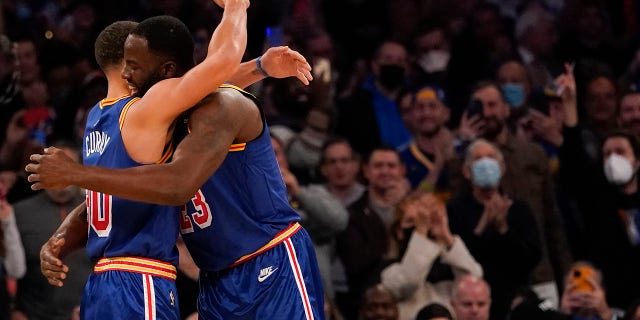 Golden State Warriors guard Stephen Curry (30) hugs forward Draymond Green (23) after scoring a 3-point basket during the first half of an NBA basketball game against the New York Knicks, Tuesday, Dec. 14, 2021, at Madison Square Garden in New York.