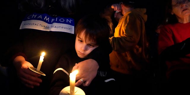 A young boy holds a candle during a vigil in the aftermath of tornadoes that tore through the region several days earlier, in Mayfield, Ky., late Tuesday, Dec. 14, 2021. 