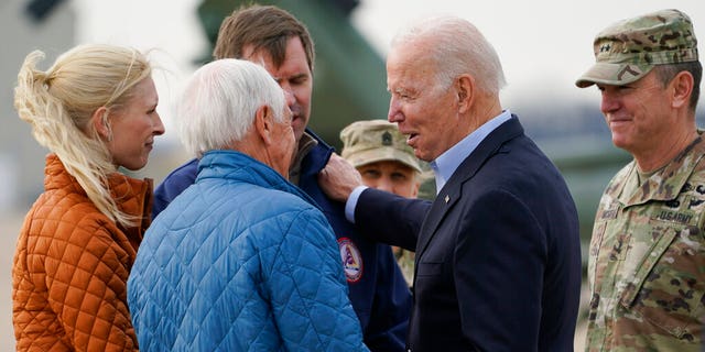 President Joe Biden greets former Gov. Steve Beshear, second from left, Kentucky Gov. Andy Beshear, third from left, and his wife Britainy Beshear, left, as he arrives in Fort Campbell, Ky., Wednesday, Dec. 15, 2021, to survey storm damage from tornadoes and extreme weather. Gen. Joseph P McGee, Commanding General, 101st Airborne Division is at right. 