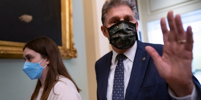 Sen. Joe Manchin walks past reporters after attending a Democratic caucus meeting Dec. 16, 2021.