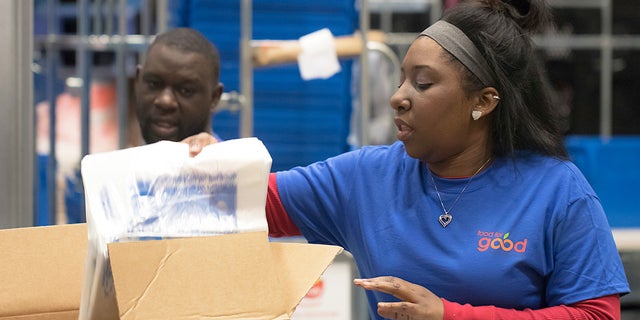 In this 2018 photo provided by Holt Haynsworth, Portia Thomas packs boxes at the Food For Good Warehouse in Austin, Texas en 2018. (Holt Haynsworth via AP)