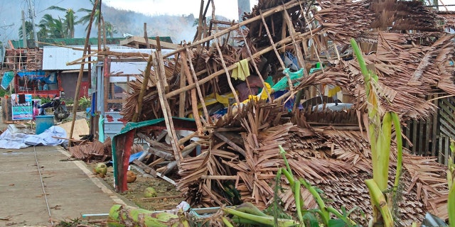In this photo provided by the Philippine Coast Guard, a house damaged by Typhoon Rai lies along a road in Surigao del Norte province, southern Philippines on Saturday, Dec. 18, 2021.