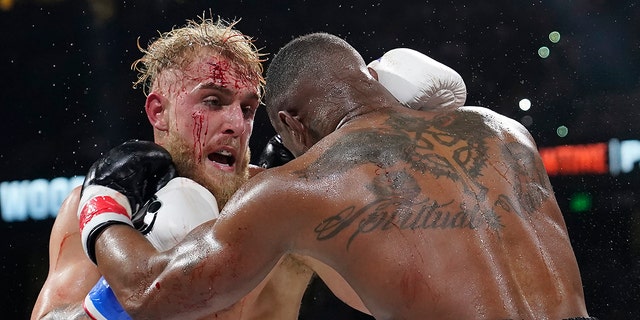 Jake Paul, left, punches Tyron Woodley during the third round of a Cruiserweight fight Sunday, Dec. 19, 2021, in Tampa, Fla. 