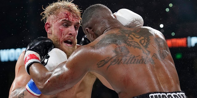 Jake Paul, left, punches Tyron Woodley during the third round of a Cruiserweight fight Sunday, Dec. 19, 2021, in Tampa, Fla.
