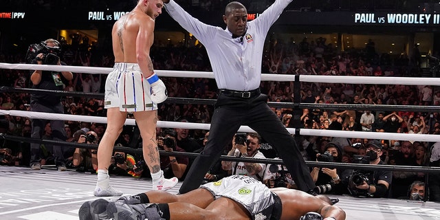 Jake Paul, left, looks back after knocking out Tyron Woodley during the sixth round of a Cruiserweight fight Sunday, Dec. 19, 2021, in Tampa, Fla. (AP Photo/Chris O'Meara)
