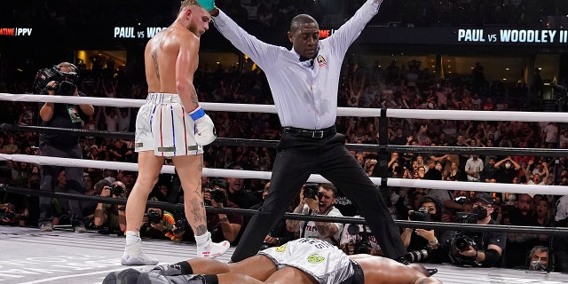 Jake Paul, left, looks back after knocking out Tyron Woodley during the sixth round of a Cruiserweight fight Sunday, Dec. 19, 2021, in Tampa, Fla. (AP Photo/Chris O'Meara)