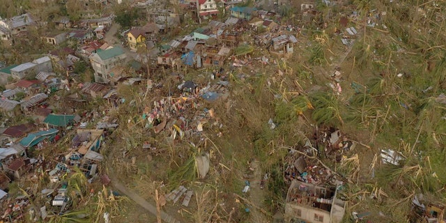 Damaged houses and toppled trees lie in Dinagat Island, Surigao del Norte province, southern Philippines on Friday, Dec. 17, 2021.