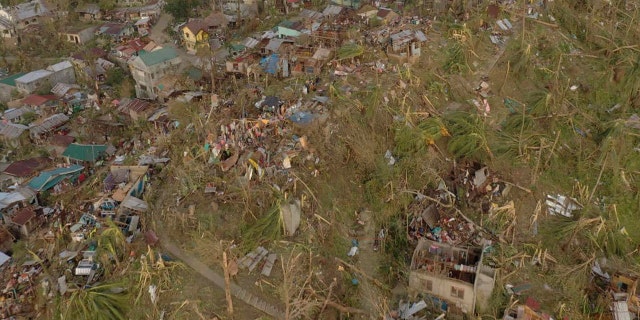 Damaged houses and toppled trees lie in Dinagat Island, Surigao del Norte province, southern Philippines on Friday, Dec. 17, 2021.