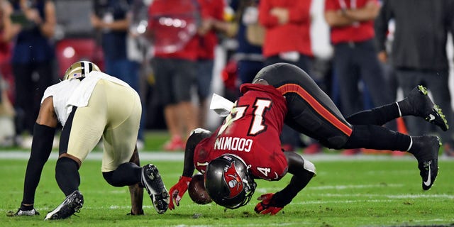 Tampa Bay Buccaneers wide receiver Chris Godwin (14) can't hang onto a pass after getting hit by New Orleans Saints cornerback P.J. Williams (26) during the first half of an NFL football game Sunday, Dec. 19, 2021, in Tampa, Florida.