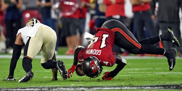 Tampa Bay Buccaneers wide receiver Chris Godwin (14) can't hang onto a pass after getting hit by New Orleans Saints cornerback P.J. Williams (26) during the first half of an NFL football game Sunday, Dec. 19, 2021, in Tampa, Florida.