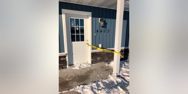 Police tape remained attached to the door of this twin home in Moorhead, Minn., on Monday, Dec. 20, 2021, marking the site where seven bodies were discovered by people conducting a welfare check.