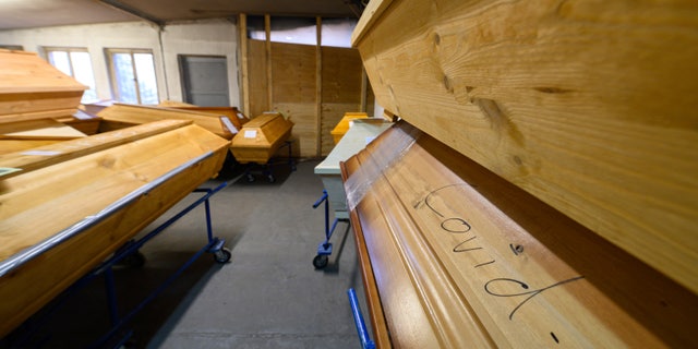 A coffin containing a deceased person who died of or with the coronavirus is labeled "Covid-19" and is in cold storage with other coffins at the crematory in Meissen, Germany, Tuesday, Dec. 21, 2021. (Robert Michael/dpa via AP)