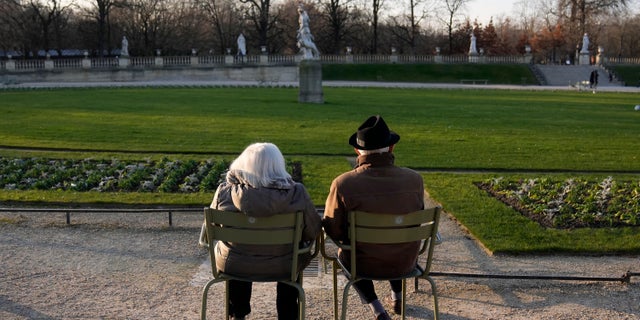 Les gens prennent le soleil dans le jardin du Luxembourg à côté du Sénat français, à Paris, France, le mardi 21 décembre 2021. (AP Photo/Francois Mori)