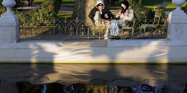 People take the sun in the Luxembourg garden next to the French Senat, in Paris, France, Tuesday, Dec. 21, 2021. (AP Photo/Francois Mori)