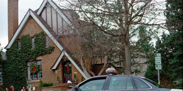 In this Jan. 3, 1997, file photo, a police officer sits in her cruiser outside the home in which 6-year-old JonBenet Ramsey was found murdered in Boulder, Colorado. 