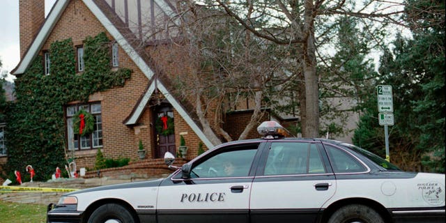 In this Jan. 3, 1997, file photo, a police officer sits in her cruiser outside the home in which 6-year-old JonBenet Ramsey was found murdered in Boulder, Colorado. 