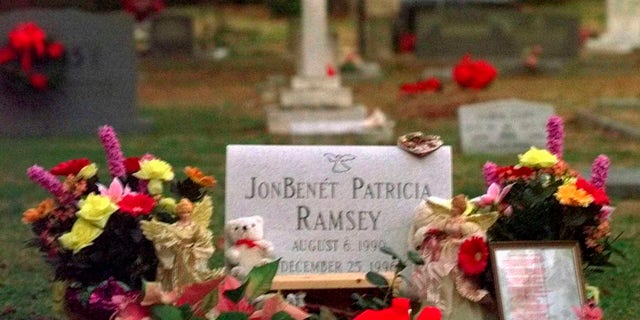 Flowers, pictures and stuffed animals adorn the gravesite of JonBenet Patricia Ramsey on Dec. 26, 1997, at the St. James Episcopal Church Cemetery in Marietta, Ga. (AP Photo/Ric Feld, File)