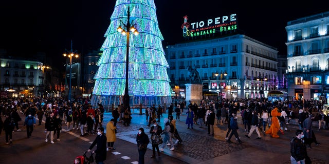 People walk along Sol square in downtown Madrid, Spain, Tuesday, Dec. 21, 2021. (AP Photo/Bernat Armangue)
