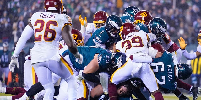 Philadelphia Eagles quarterback Jalen Hurts (1), center, runs for a touchdown during the second half of an NFL football game against the Washington Football Team, Tuesday, Dec. 21, 2021, in Philadelphia. (AP Photo/Matt Rourke)