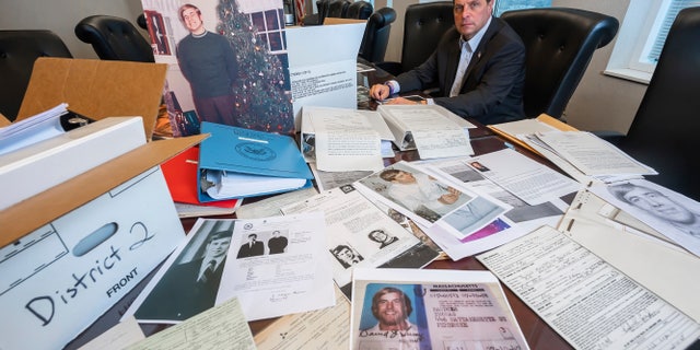 U.S. Marshal Peter J. Elliott poses for a photo on Dec. 16, 2021 at the Carl B. Stokes U.S. Courthouse in Cleveland with items related to a 1969 bank robbery. (AP Photo/Ken Blaze)