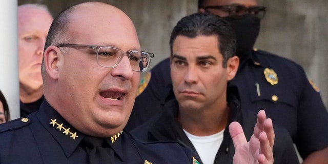 Miami Police interim Chief Manuel Morales, foreground and Mayor Francis Suarez, right, announce the arrest of a real estate agent suspected of hunting homeless people, Thursday, Dec. 23, 2021, during a news conference at the Miami Police Department in Miami. (AP Photo/Wilfredo Lee)