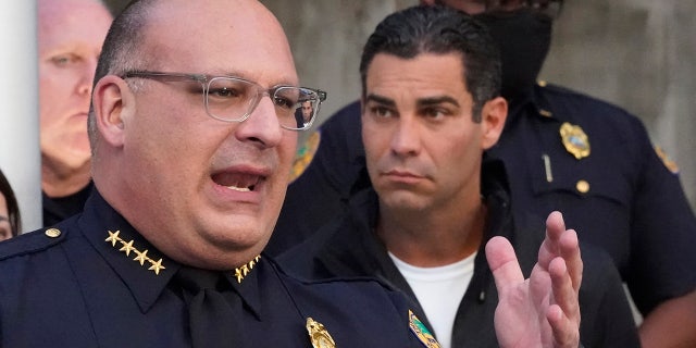 Miami Police interim Chief Manuel Morales, foreground and Mayor Francis Suarez, right, announce the arrest of a real estate agent suspected of hunting homeless people, Thursday, Dec. 23, 2021, during a news conference at the Miami Police Department in Miami. (AP Photo/Wilfredo Lee)