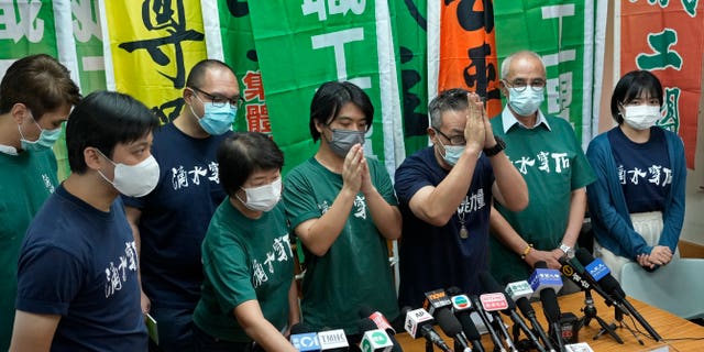 Hong Kong Confederation of Trade Unions President Joe Wong Nai-yuen, third from right, with deep blue T-shirt, gestures while posing for a photo with other members before a news conference on the possibility of disbandment in Hong Kong Sunday, Sept. 19, 2021. (AP Photo/Vincent Yu, File)