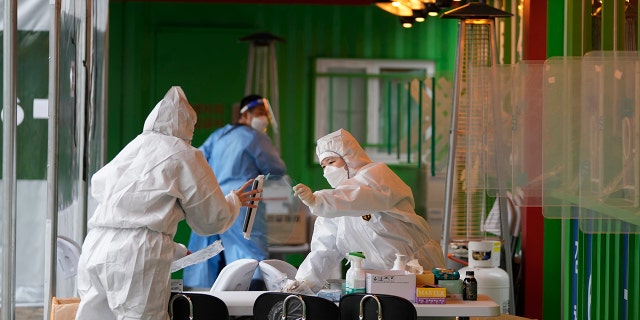 Some Vaccine Mandates May Leave US Vulnerable At Home And Abroad As Omicron Numbers Surge - Fox News 4 Medical workers wearing protective gear prepare to take samples at a temporary screening clinic for the coronavirus in Seoul, South Korea, Wednesday, Dec. 29, 2021.