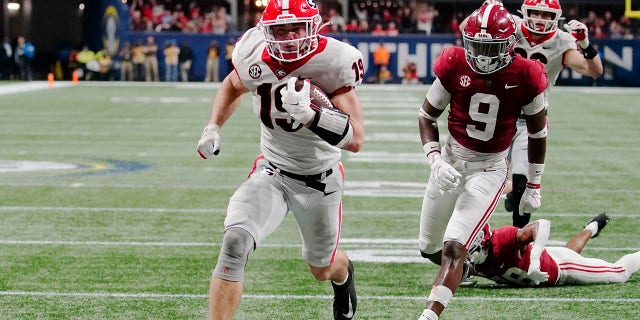 FILE - Georgia tight end Brock Bowers (19) runs into the end zone for a touchdown against Alabama defensive back Jordan Battle (9) during the second half of the Southeastern Conference championship NCAA college football game, Saturday, Dec. 4, 2021, in Atlanta.