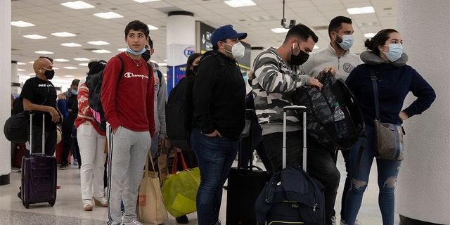 Travelers make their way through Miami International Airport on Dec. 23, 2021, in Miami, Florida.