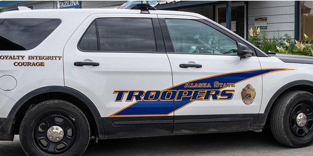 An Alaska State Troopers police SUV vehicle is parked outside of a store.