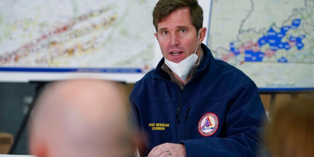 Democratic Kentucky Gov.  Andy Beshear speaks as he attends a briefing from local leaders on the storm damage from tornadoes and extreme weather with President Biden at Mayfield Graves County Airport in Mayfield, Ky., Dec. 15, 2021.