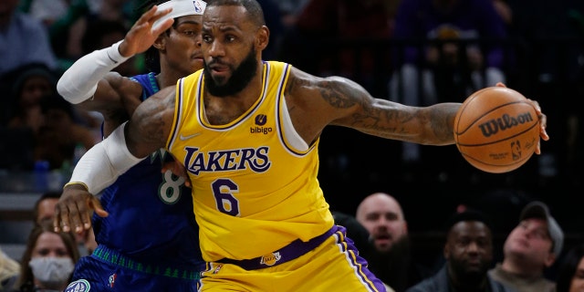 Los Angeles Lakers forward LeBron James (6) works to the basket around Minnesota Timberwolves forward Jarred Vanderbilt (8) in the third quarter Friday, Dec. 17, 2021, in Minneapolis. The Timberwolves won 110-92.
