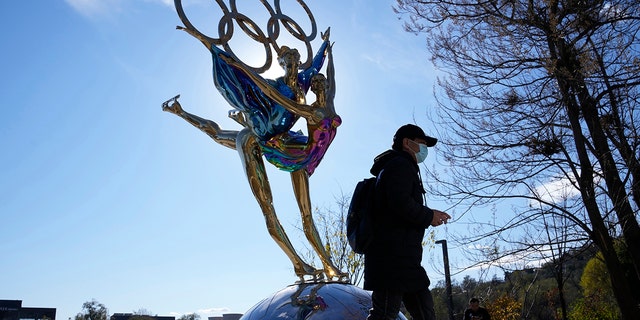 A visitor to the Shougang Park walks past a sculpture for the Beijing Winter Olympics in Beijing, China, Tuesday, Nov. 9, 2021. 