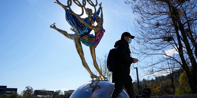 A visitor to the Shougang Park walks past a sculpture for the Beijing Winter Olympics in Beijing, China, Tuesday, Nov. 9, 2021.